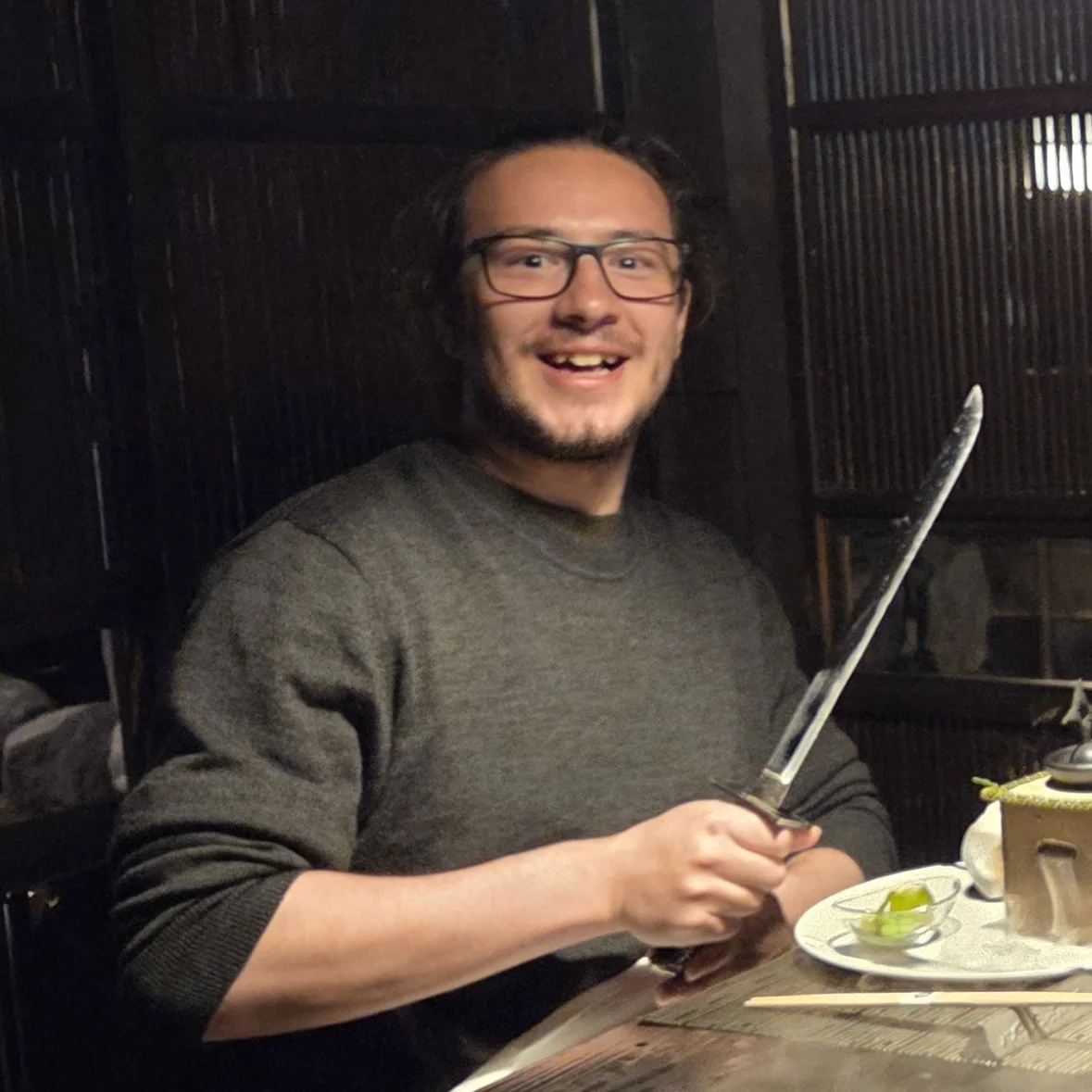 Quinn Porter holding a big knife in a japanese restaurant